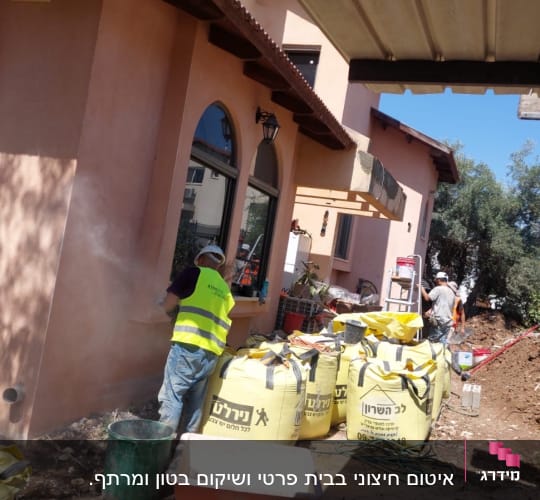 עובדים עם אפודים זוהרים ליד שקי בנייה צהובים